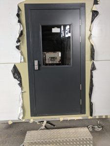 Black security door with a window and silver door handle
