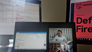Zoom meeting of two people with screens behind